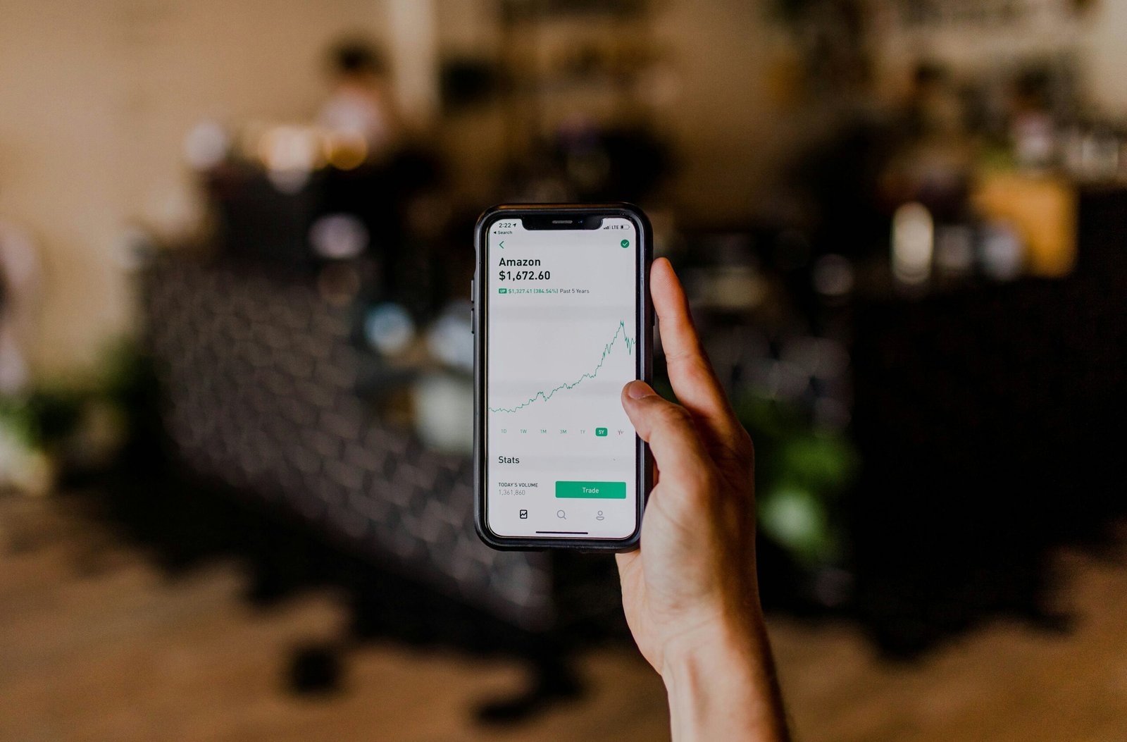 person holding black iphone person holding black iPhone displaying stock exchange